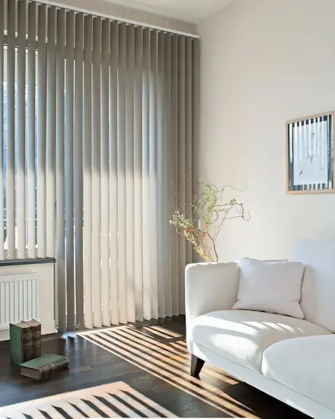 Persiana vertical gris en sala con sofá blanco