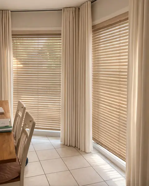 Persiana de madera clara combinada con cortinas en esquina